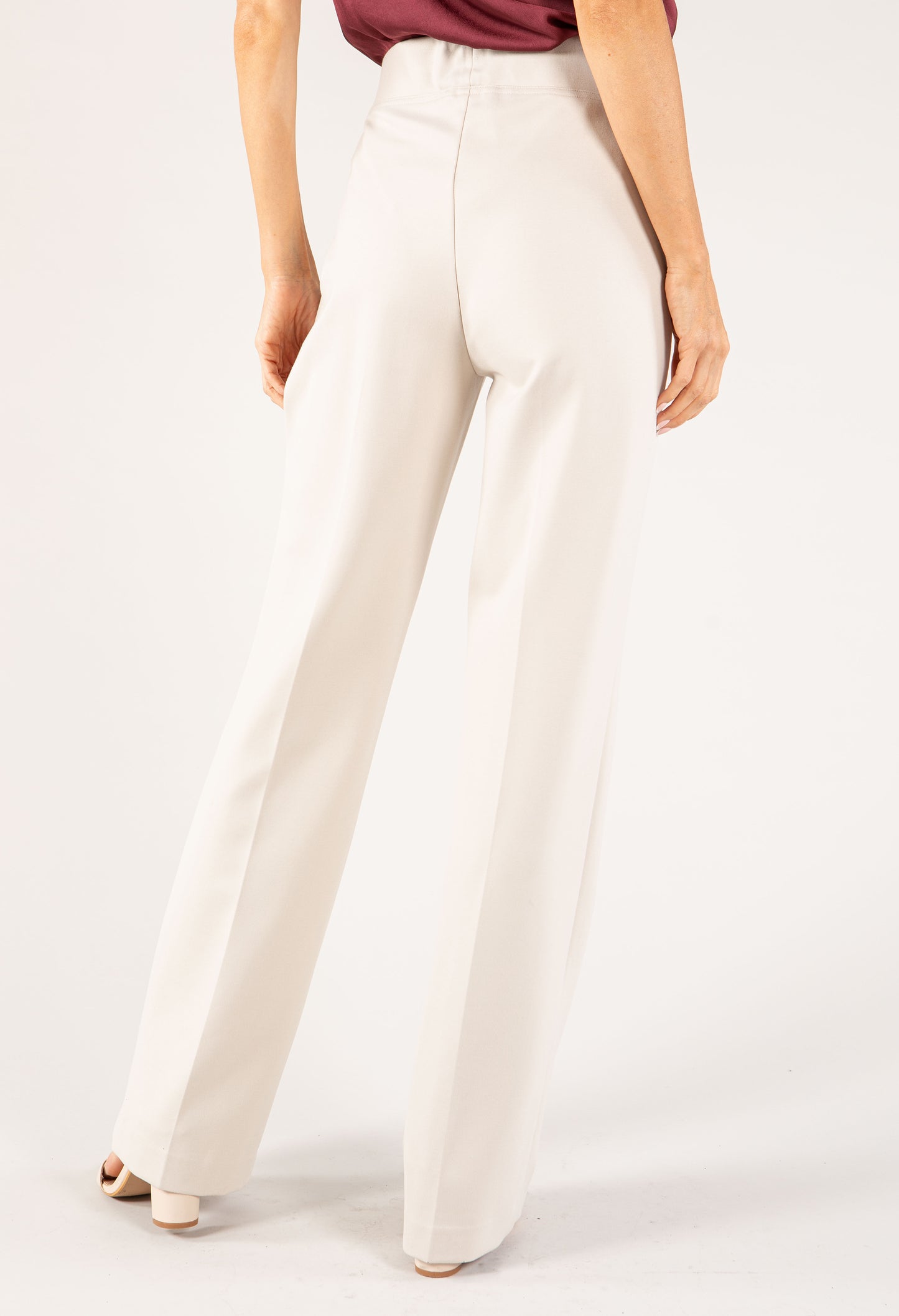 White pants worn by a person on a white background