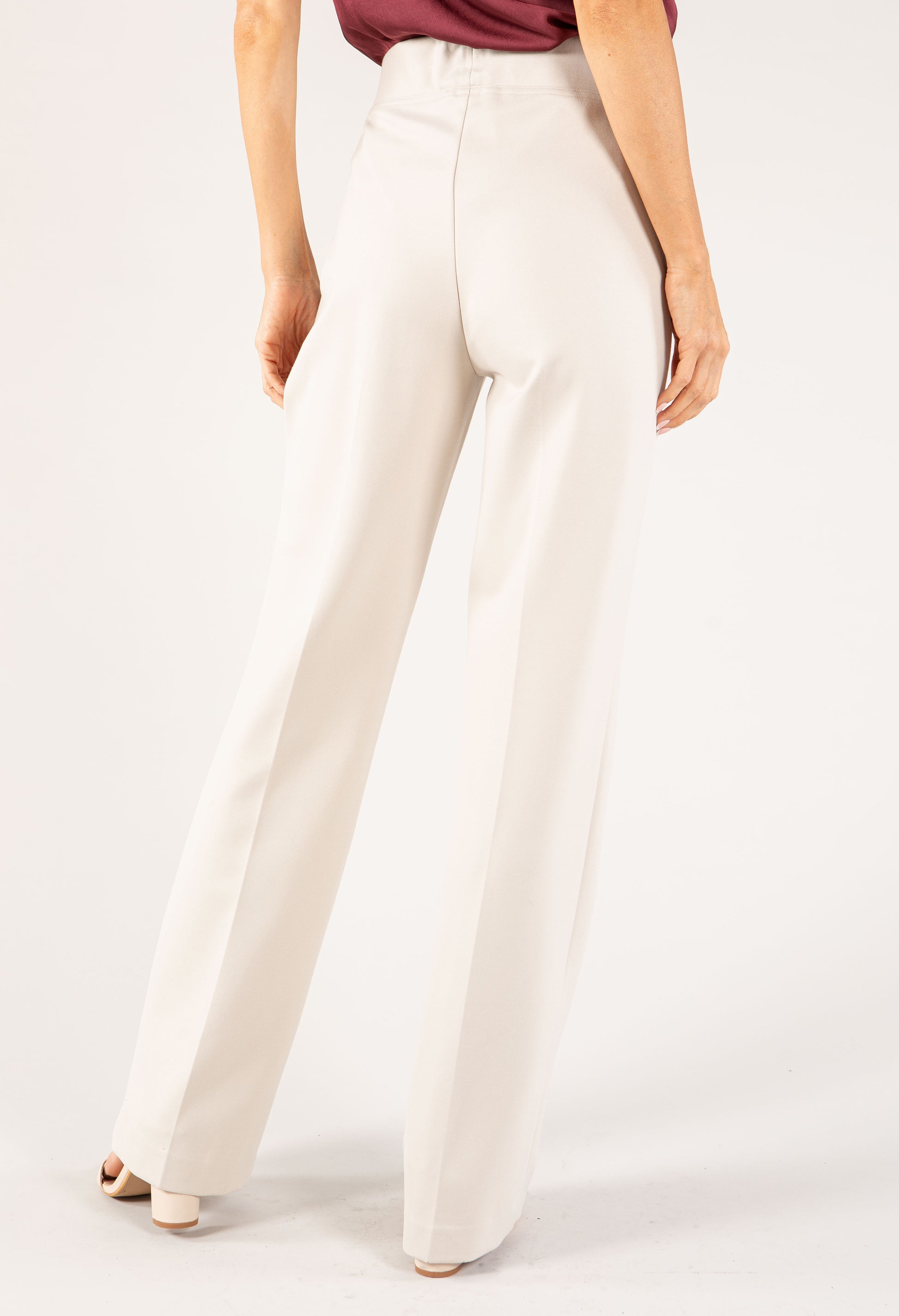 White pants worn by a person on a white background