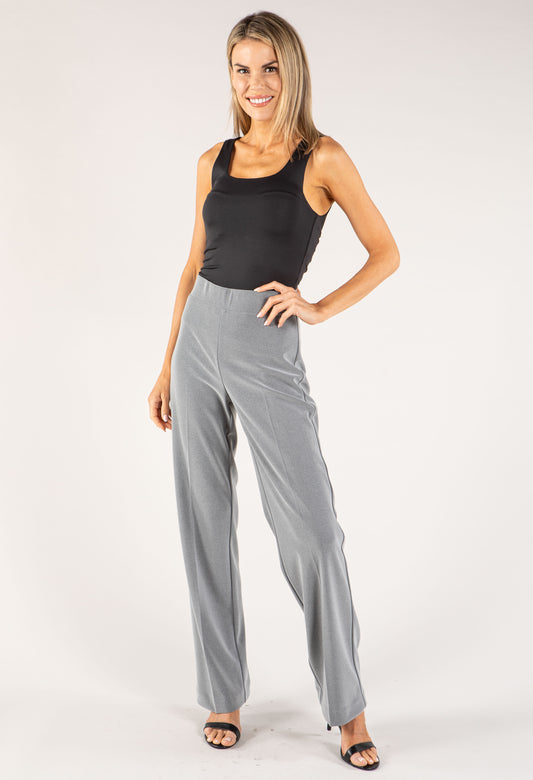 Woman wearing a black tank top and gray pants on a white background