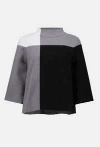 Color-blocked poncho with gray, white, and black sections on a white background
