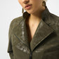 Woman wearing a green leather jacket on a white background