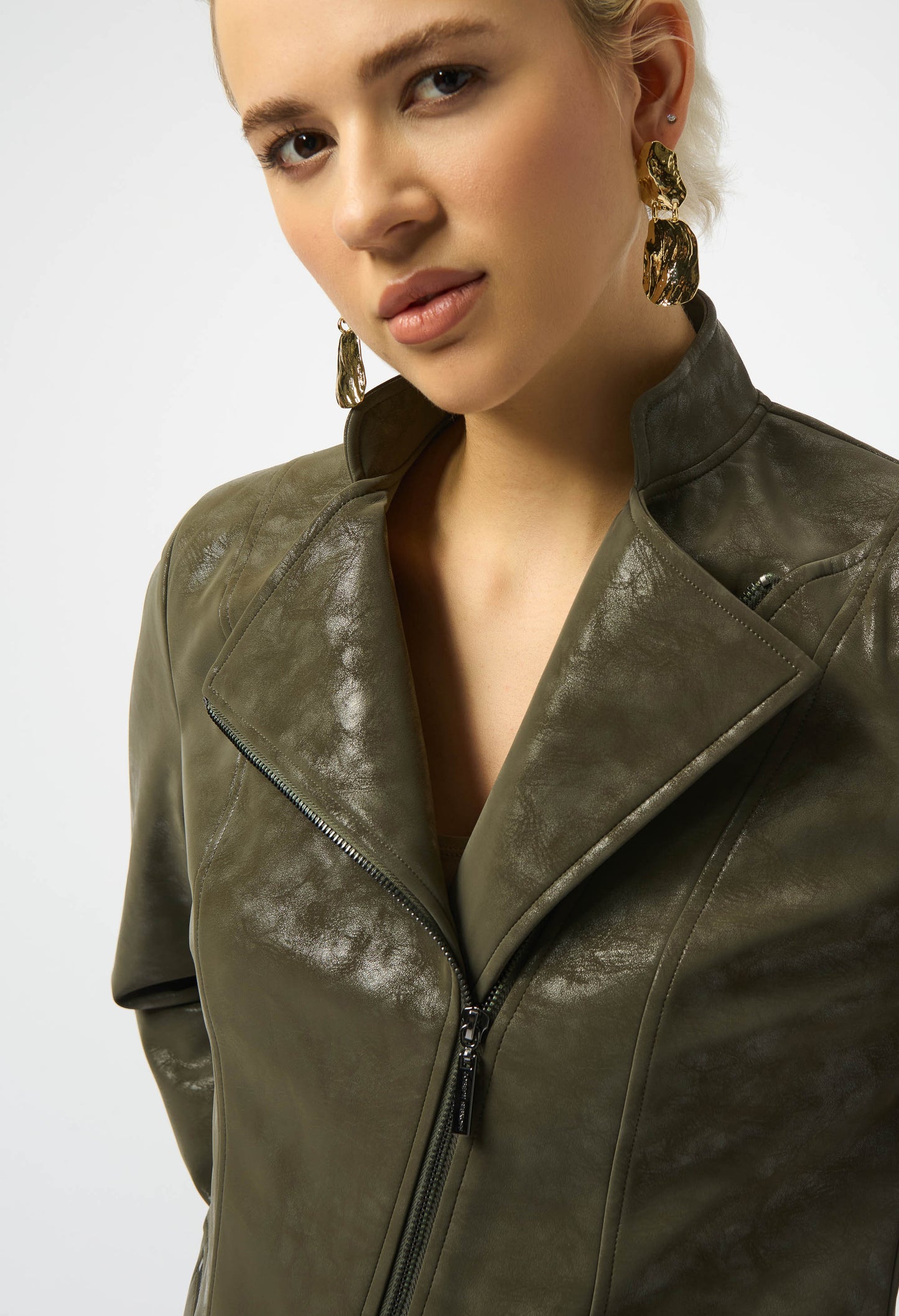 Woman wearing a green leather jacket on a white background