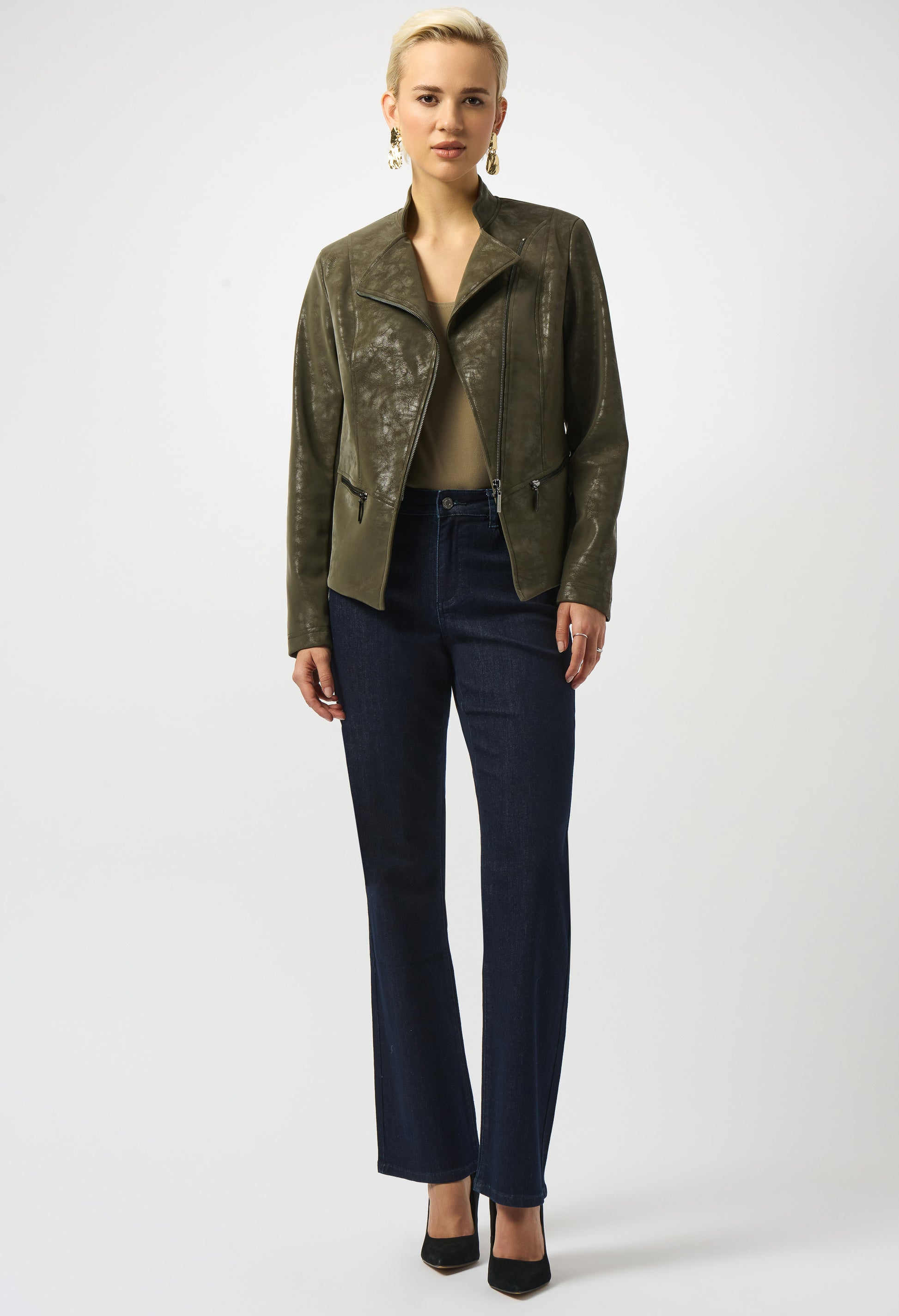 Woman wearing a green jacket and dark blue pants on a white background