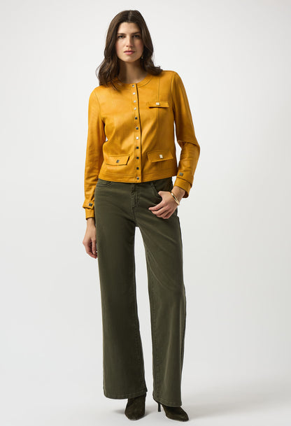 Woman wearing a mustard yellow blouse and olive green pants on a white background