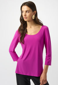 Woman wearing a bright pink long-sleeve top on a white background