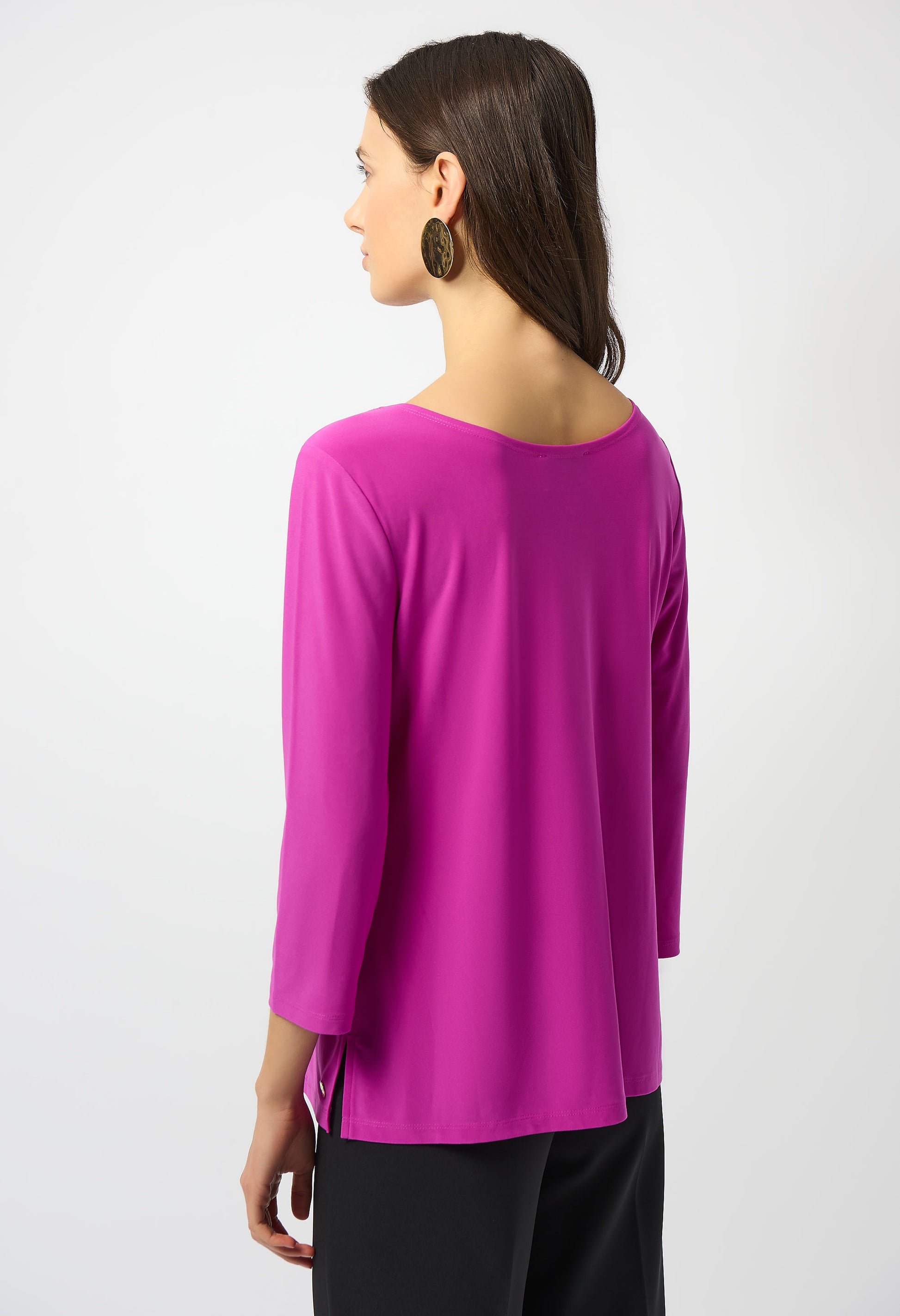 Woman wearing a bright pink long-sleeve top on a white background