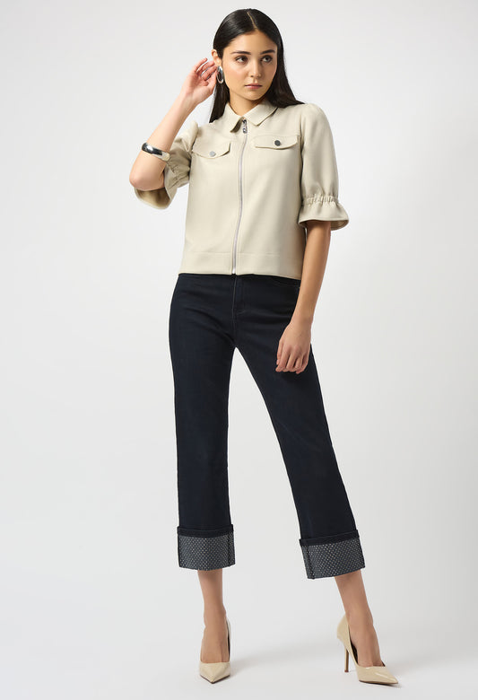 Woman wearing a beige shirt and black pants on a white background