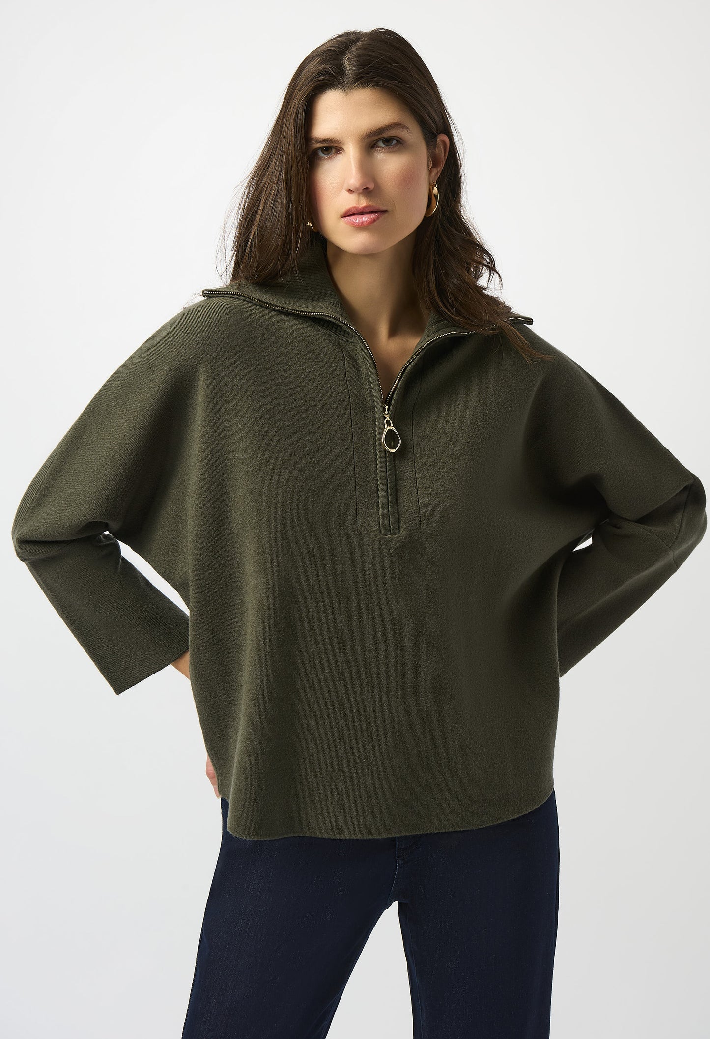 Woman wearing a green sweater with a zipper on a white background