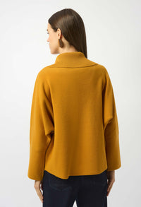 Person wearing a mustard yellow sweater on a white background