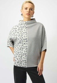 Woman wearing a patterned top with a white background