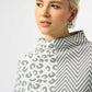 Woman wearing a patterned top with a white background
