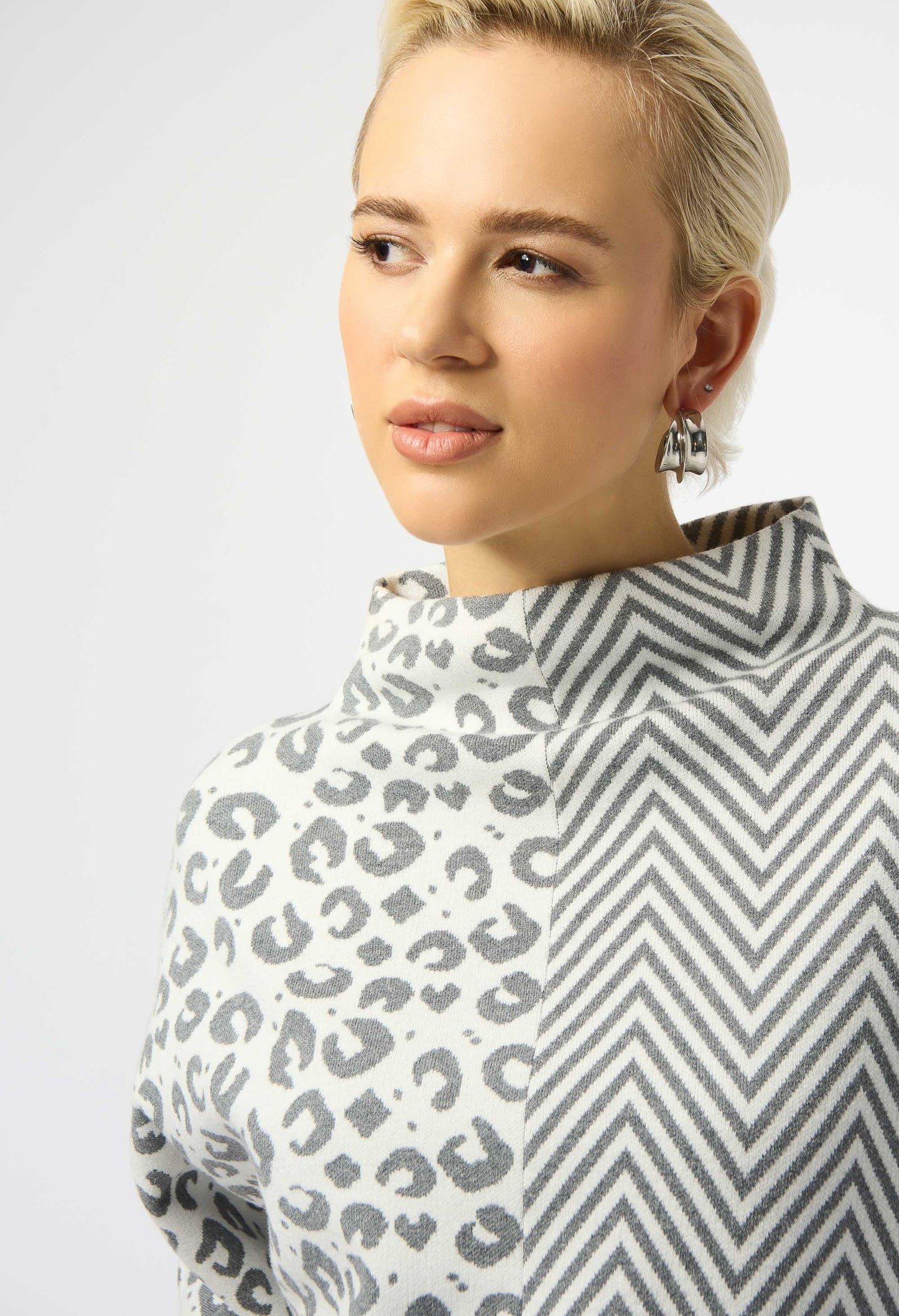 Woman wearing a patterned top with a white background