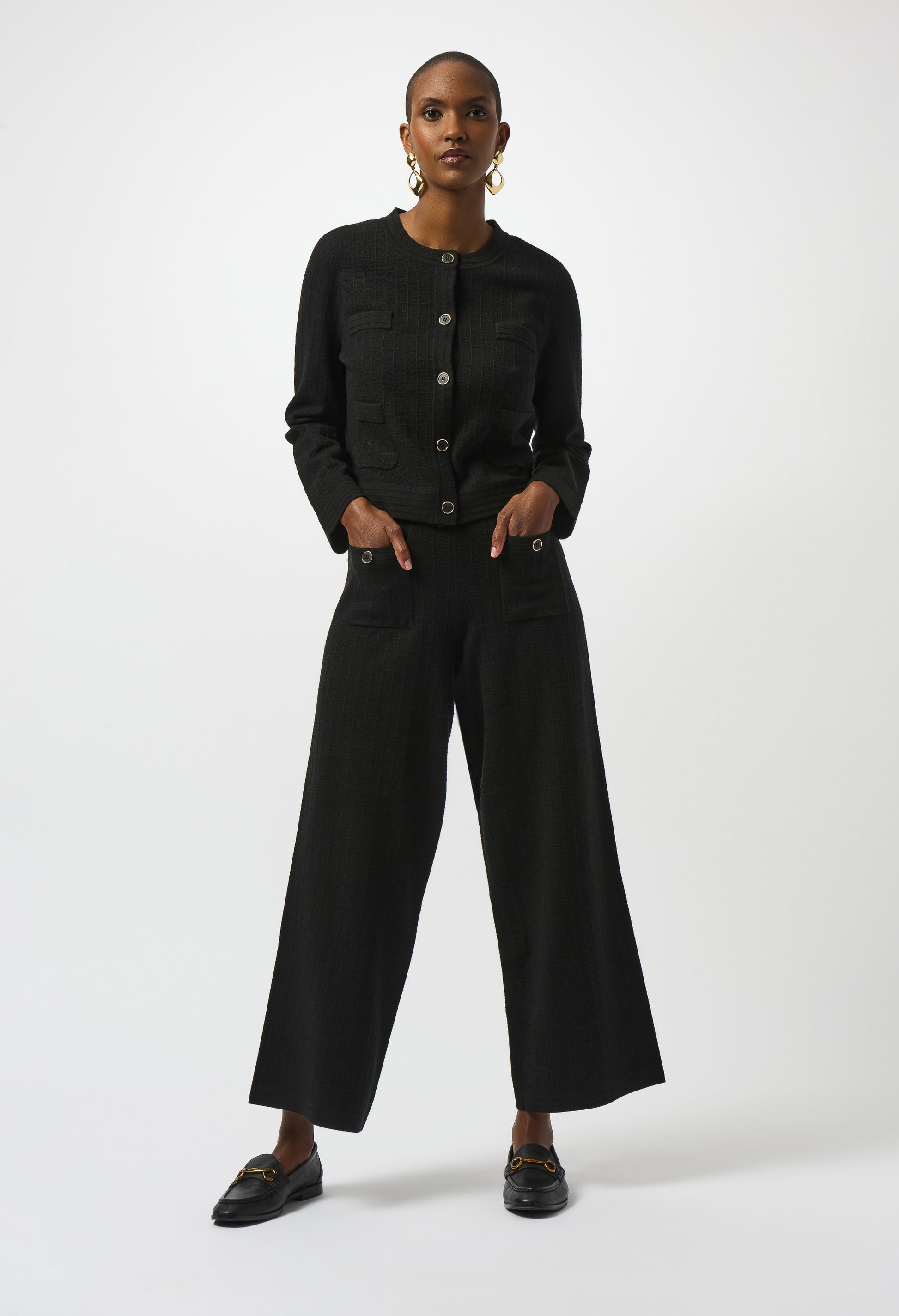 Person wearing a black outfit with wide-leg pants on a white background