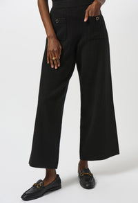 Person wearing black wide-leg pants on a white background