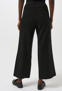 Black wide-leg pants worn by a person on a white background