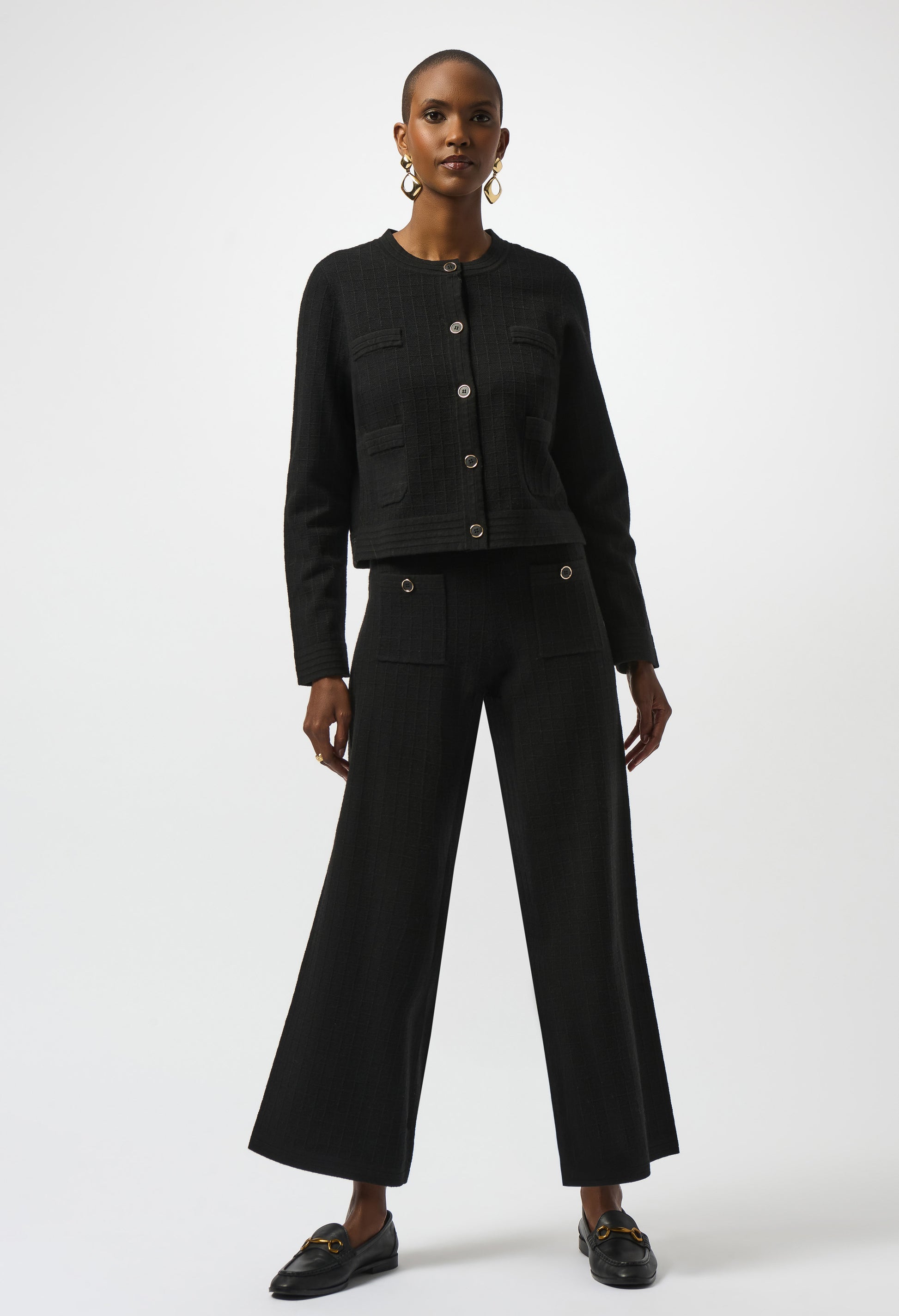 Woman wearing a black outfit with wide-leg pants on a white background
