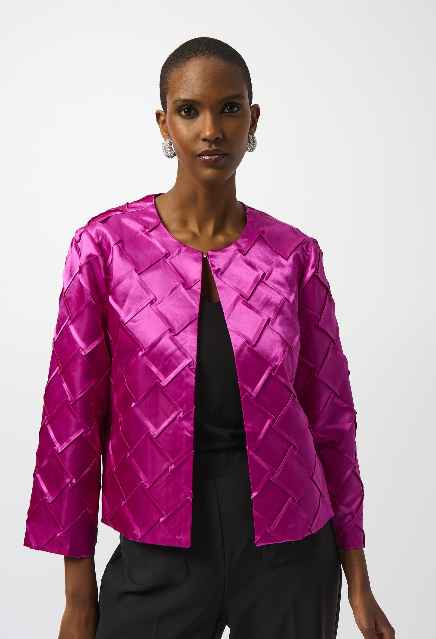 Woman wearing a bright pink quilted jacket on a white background