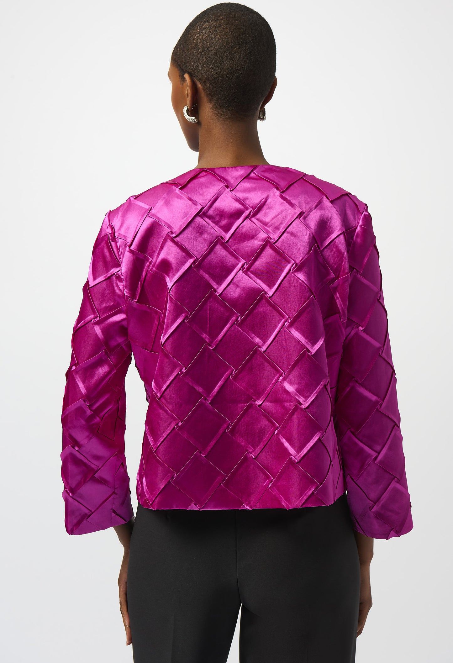 Person wearing a bright pink quilted jacket on a white background