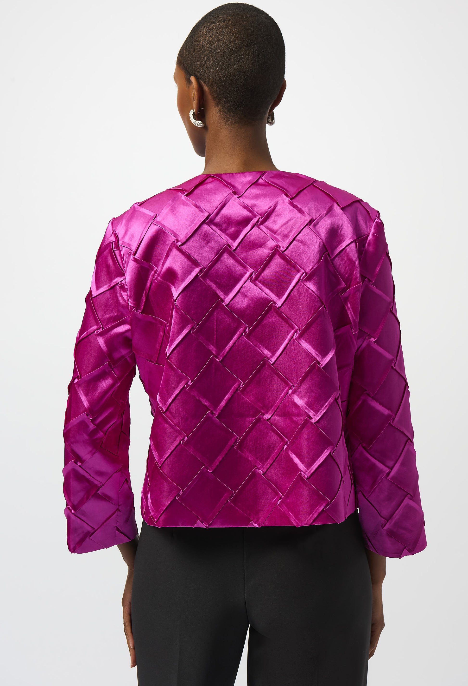 Person wearing a bright pink quilted jacket on a white background