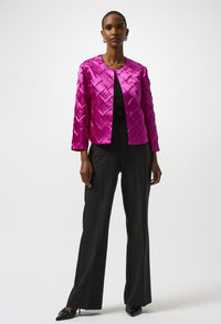 Person wearing a bright pink quilted jacket and black pants on a white background