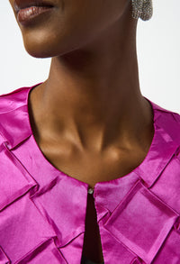 Close-up of a person wearing a bright pink satin top with a blurred background