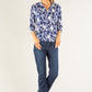 Woman wearing a blue floral blouse and jeans on a white background