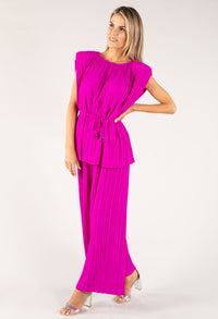 Woman wearing a bright pink dress with a belt on a white background