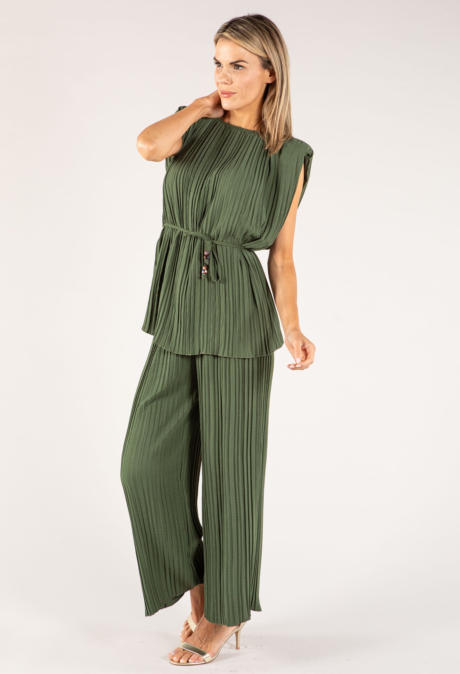 Woman wearing a green pleated outfit on a white background