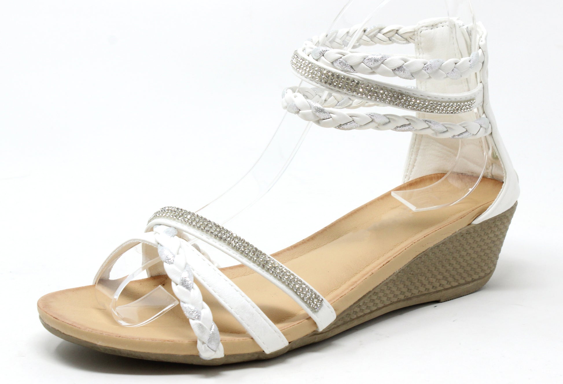 White wedge sandal with braided design on a white background
