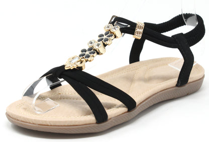 Black sandal with gold embellishments on a white background