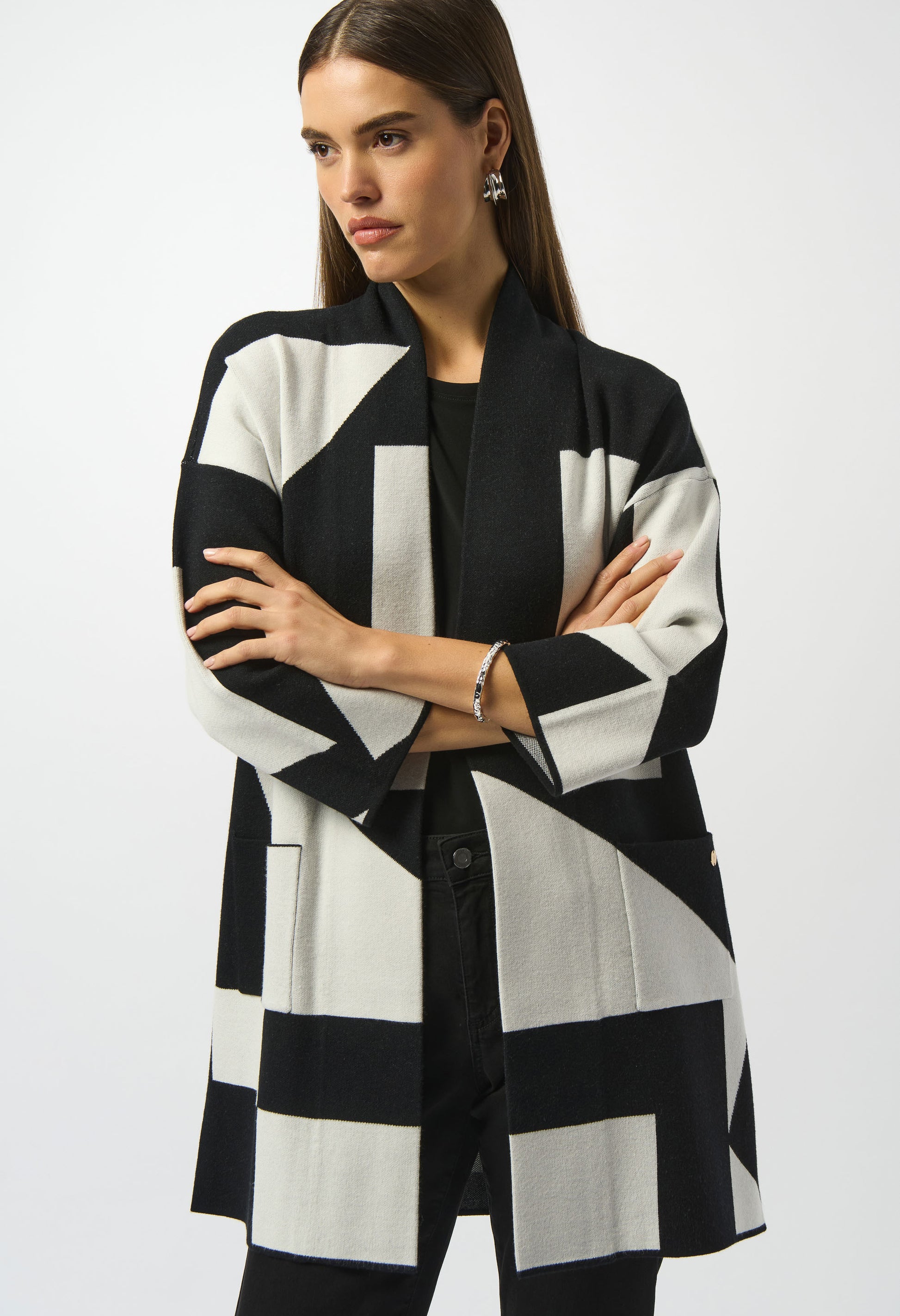 Woman wearing a black and white patterned coat on a white background