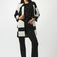 Woman wearing a black and white striped coat over a black outfit on a white background