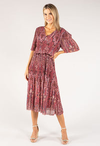 Woman wearing a patterned dress on a white background