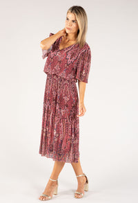 Woman wearing a patterned dress on a white background