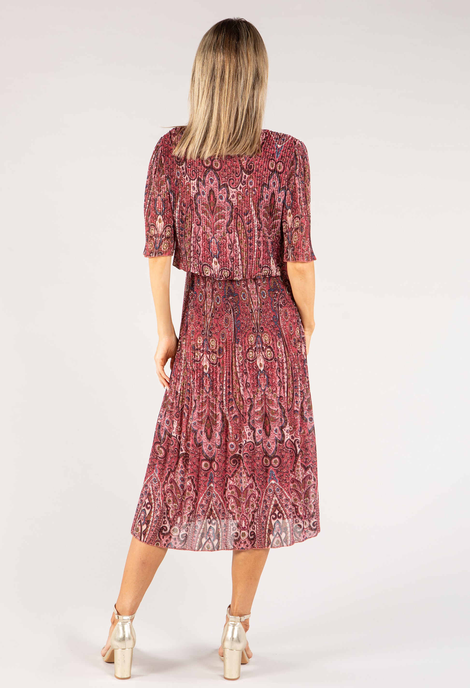 Woman wearing a red patterned dress on a white background