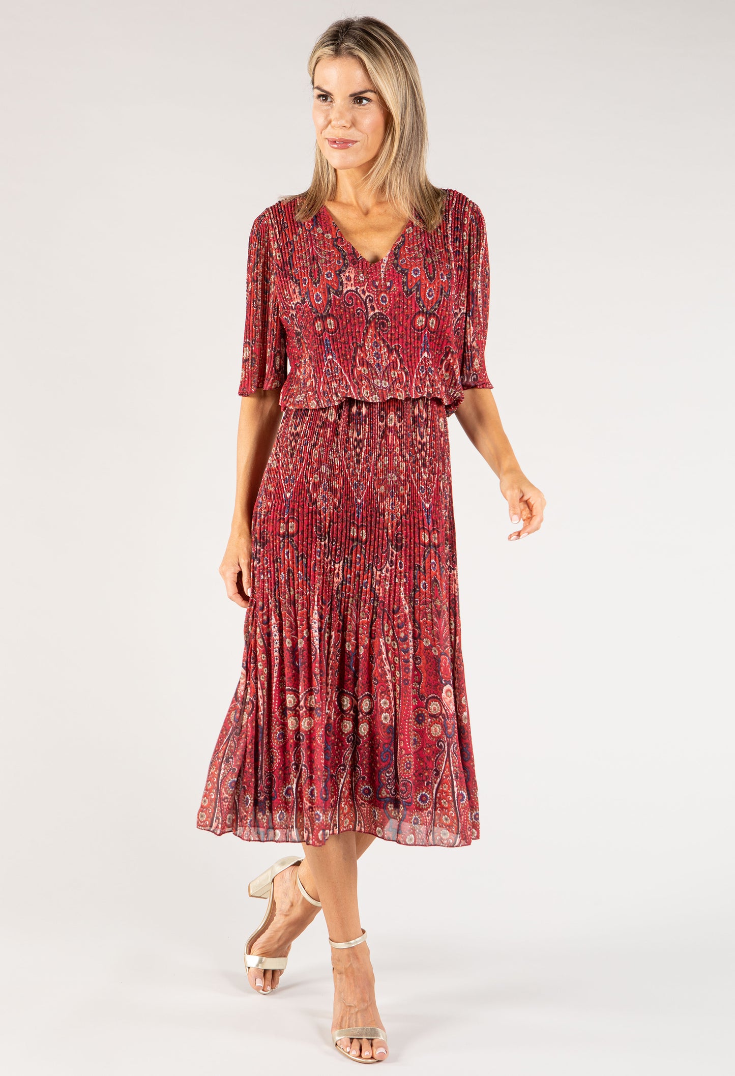 Woman wearing a red patterned dress on a white background