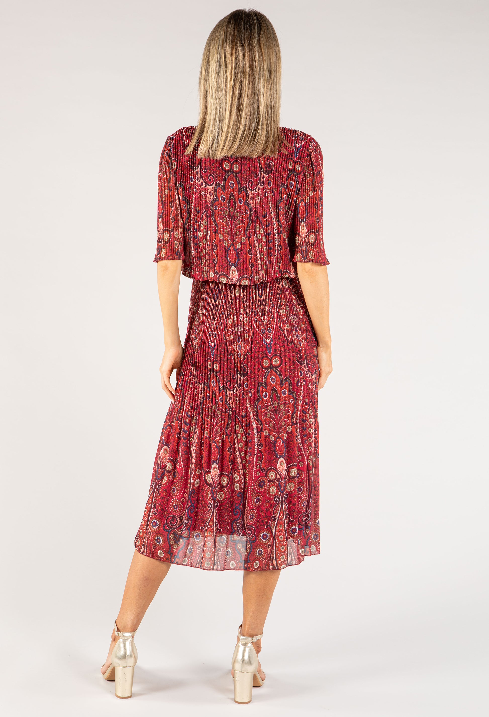 Woman wearing a red patterned dress on a white background