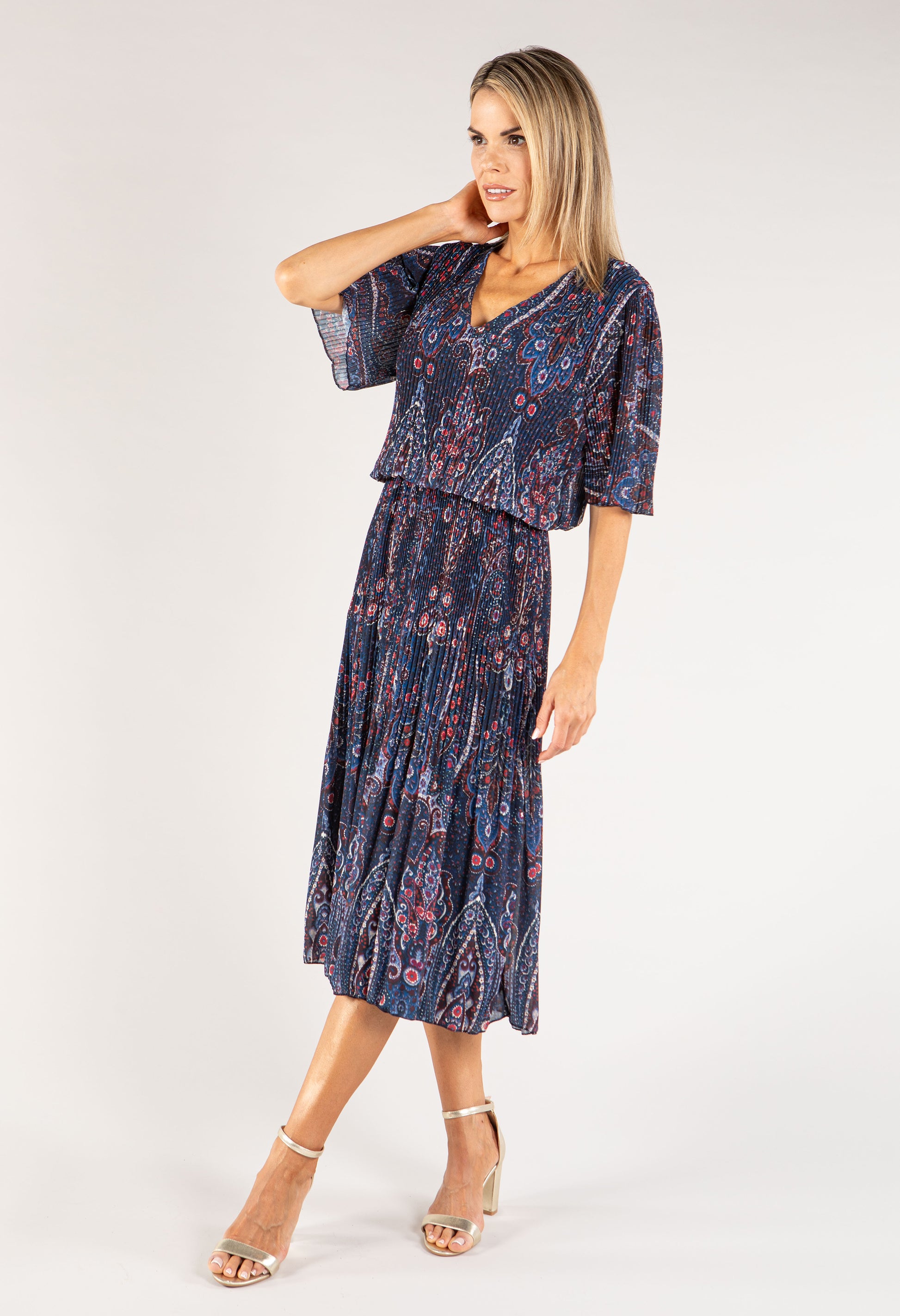 Woman wearing a navy patterned dress on a white background