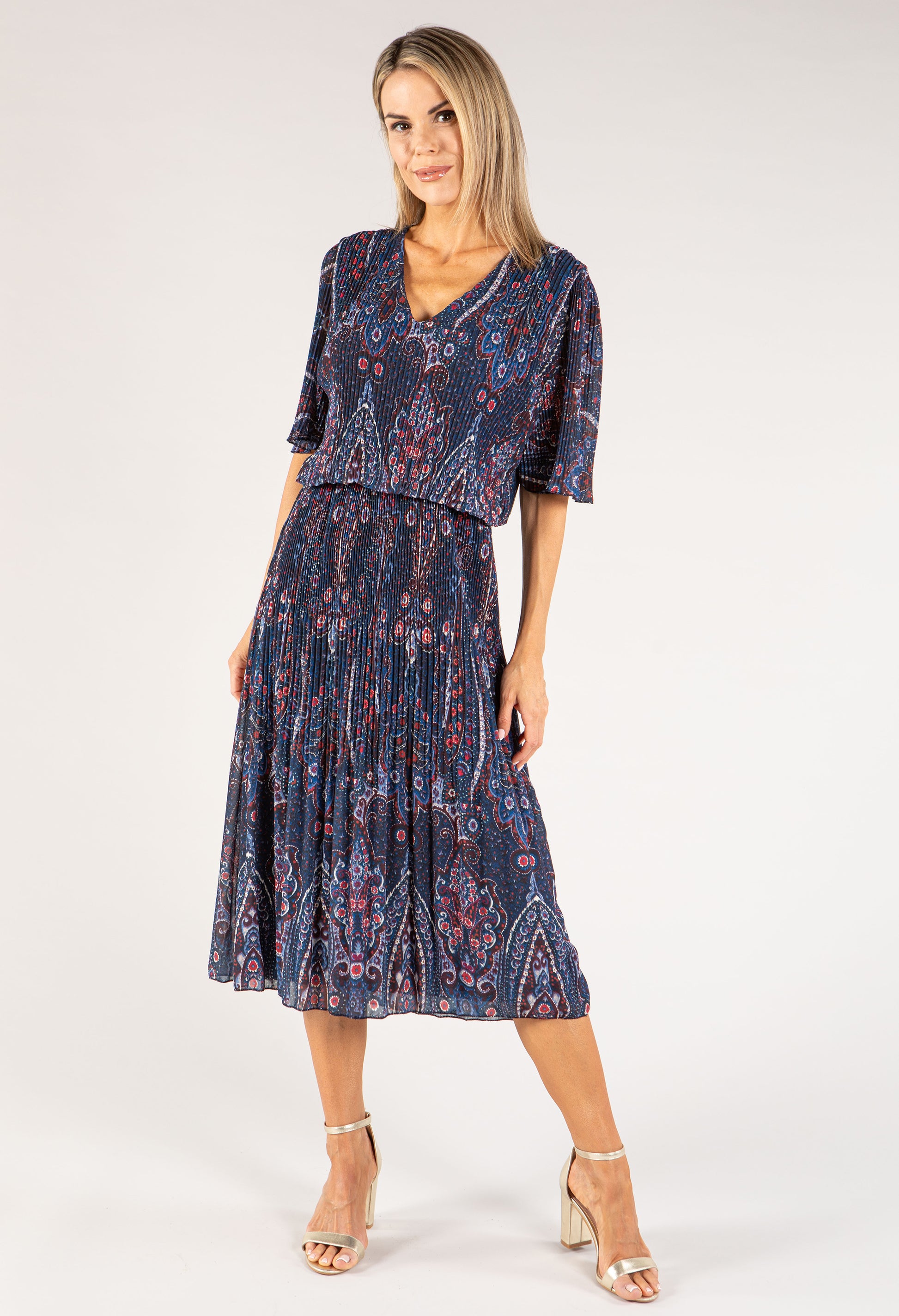 Woman wearing a navy patterned dress on a white background