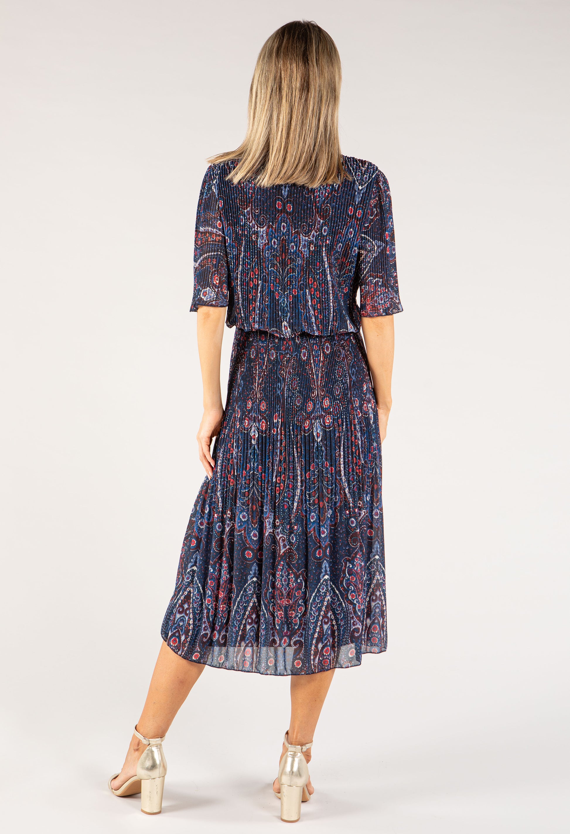 Woman wearing a patterned dress on a white background