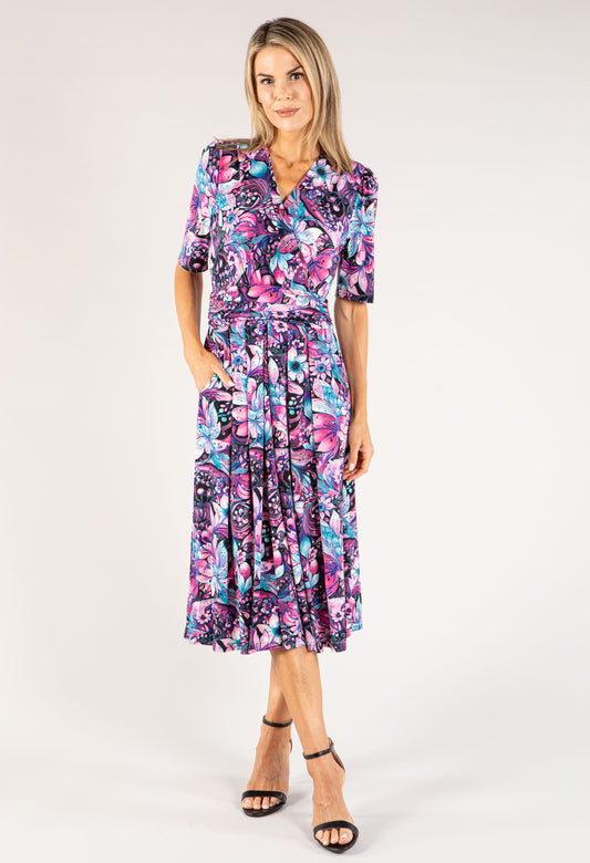 Woman wearing a colorful floral dress on a white background