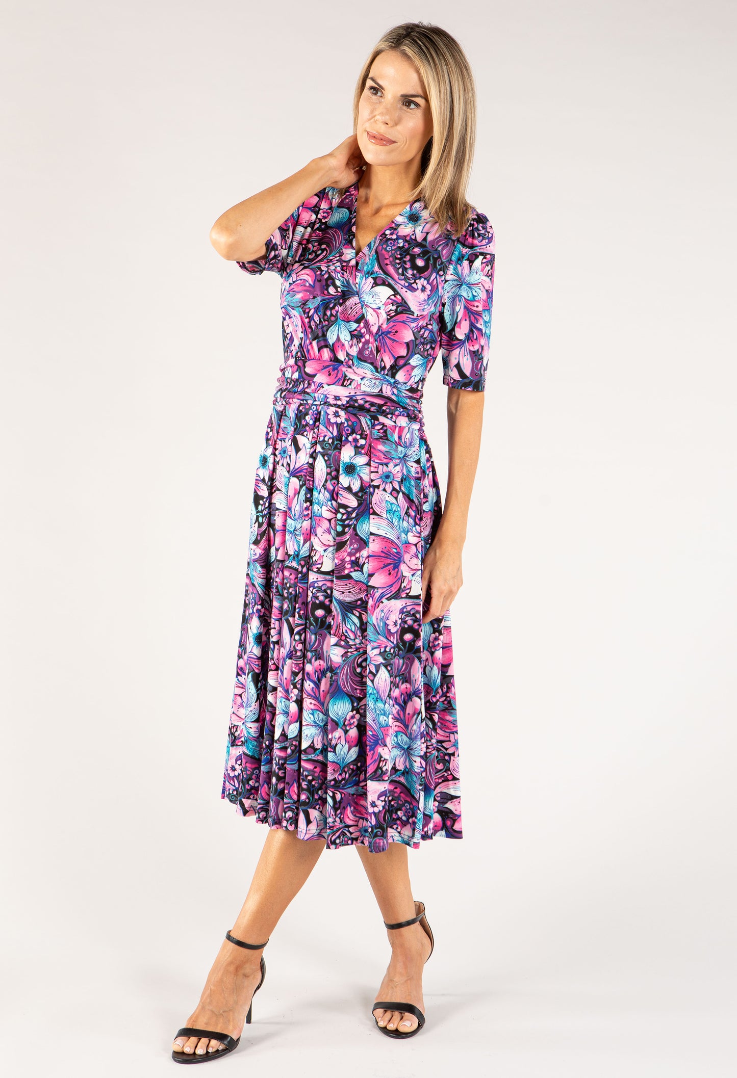 Woman wearing a colorful floral dress on a white background