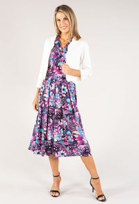 Woman wearing a floral dress with a white cardigan on a white background