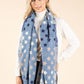 Woman wearing a blue star-patterned scarf on a beige background