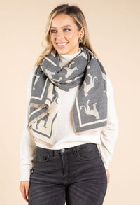 Woman wearing a gray scarf with dog patterns on a beige background