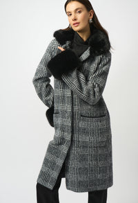 Woman wearing a checkered coat with black fur trim on a white background