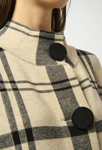 Close-up of a checkered coat with black buttons on a white background