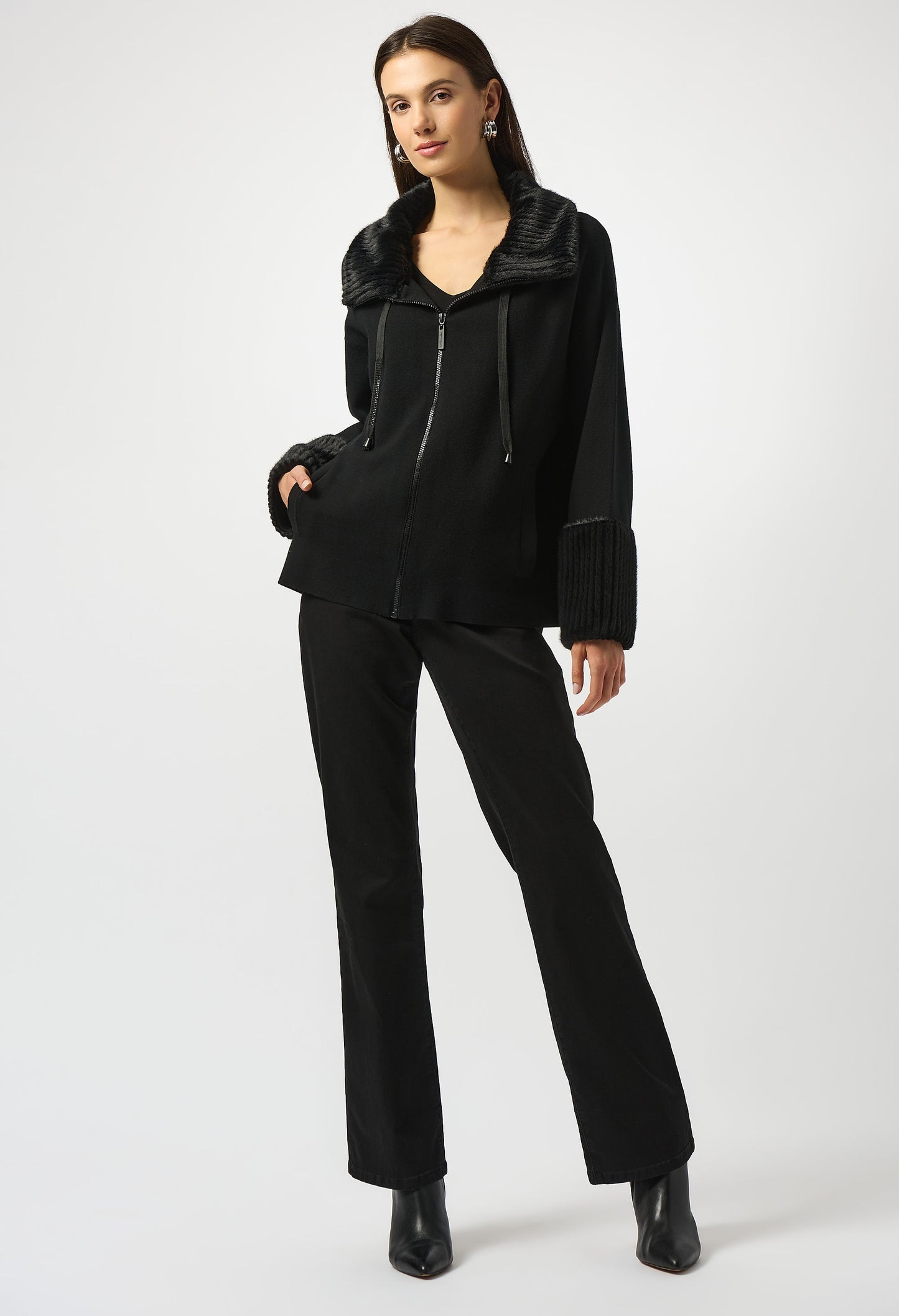 Person wearing a black outfit with a jacket and pants on a white background