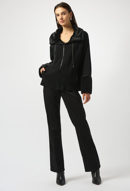 Person wearing a black outfit with a jacket and pants on a white background