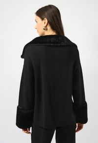 Person wearing a black coat with textured collar on a white background